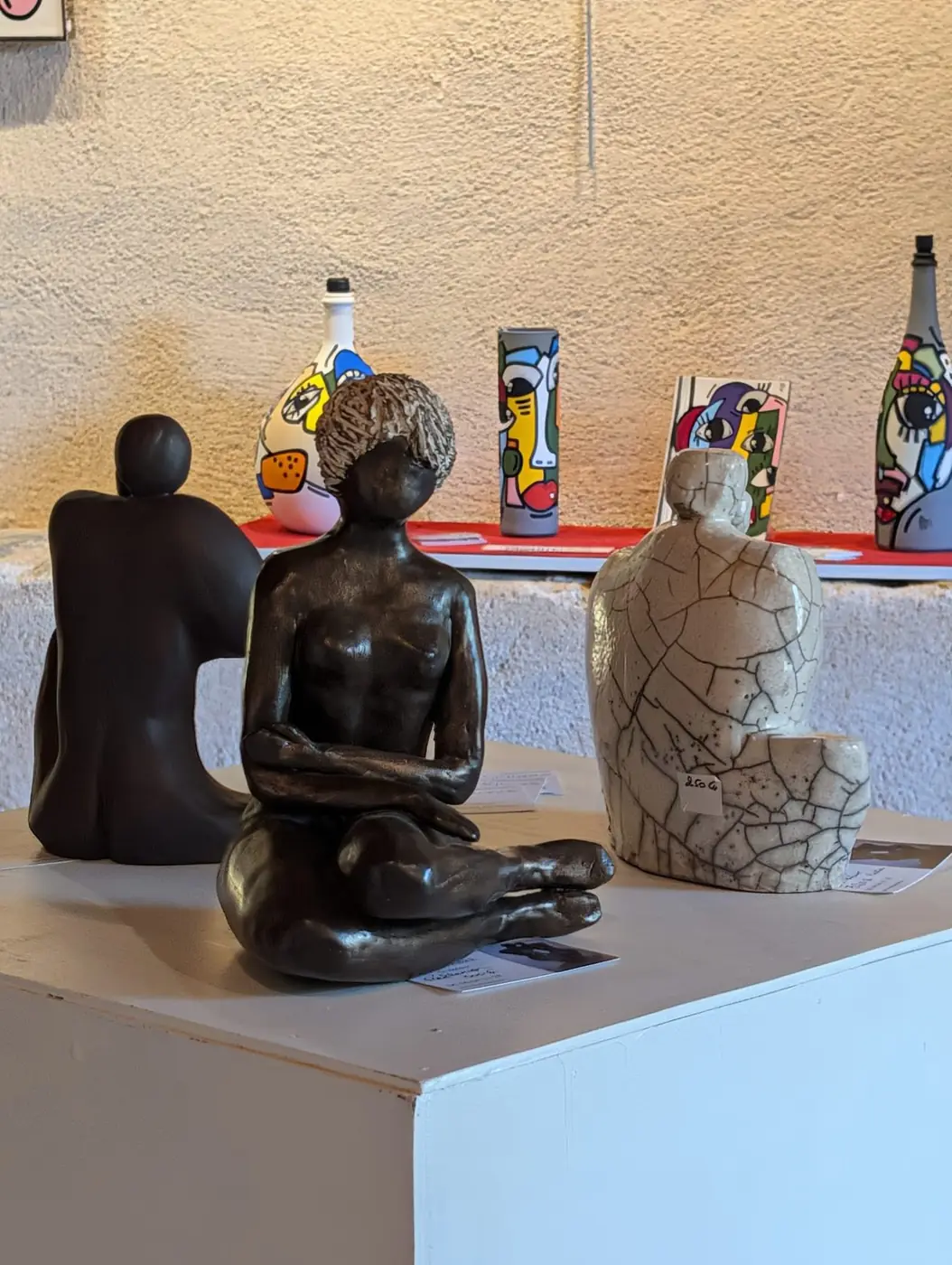 Sculptures de bronze — figures assises, œuvres d'un co-exposant