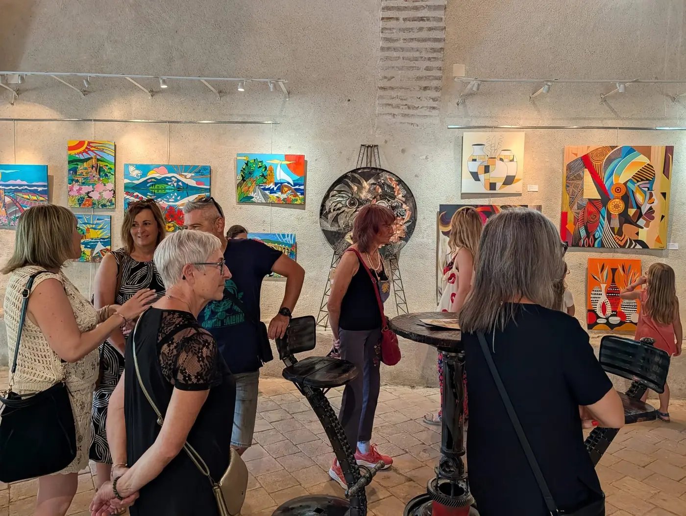 Visiteurs échangeant devant les œuvres pendant le vernissage
