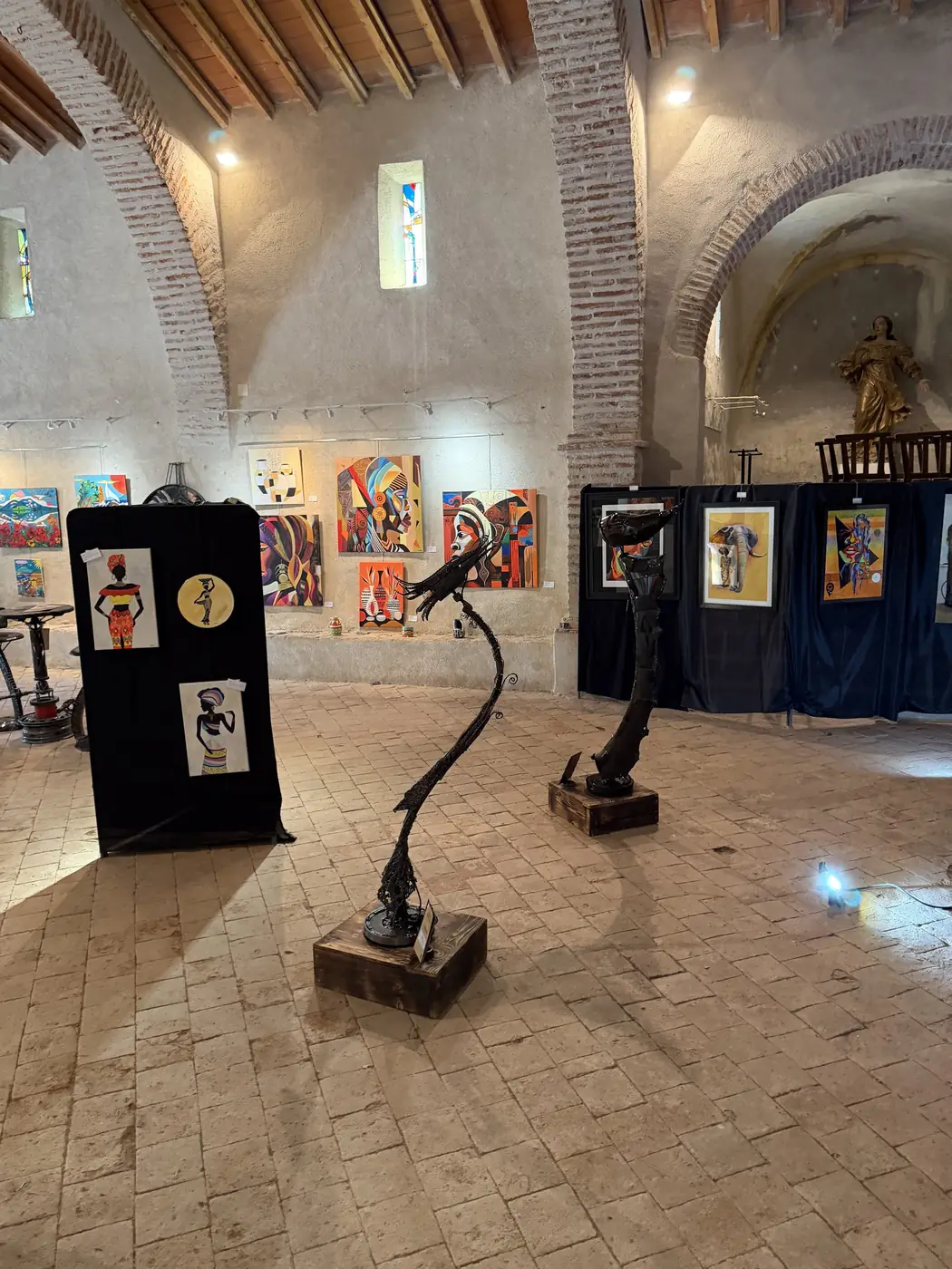 Les toiles présentées sous les voûtes de pierre de la chapelle